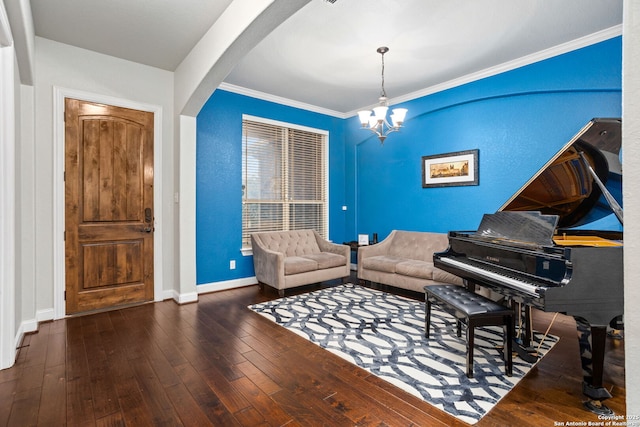 living area featuring arched walkways, a chandelier, hardwood / wood-style floors, baseboards, and ornamental molding