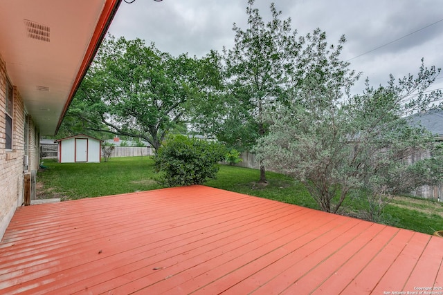 wooden deck featuring a storage shed and an outbuilding