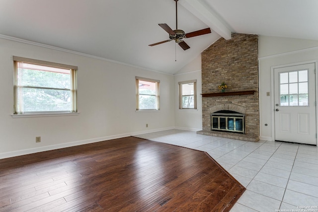 unfurnished living room with ceiling fan, light wood finished floors, baseboards, and a brick fireplace