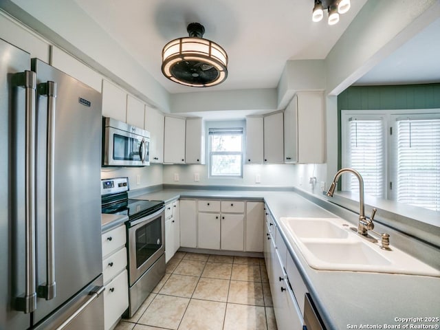 9327 Fernglen Dr, San Antonio, TX 78240 - kitchen with white cabinets, light tile patterned floors, appliances with stainless steel finishes, and a sink