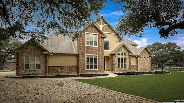 view of front facade with a standing seam roof, metal roof, and stone siding