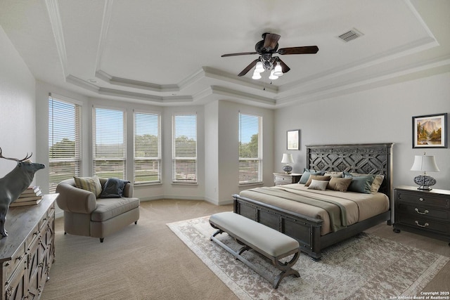 bedroom with visible vents, a raised ceiling, crown molding, and light colored carpet