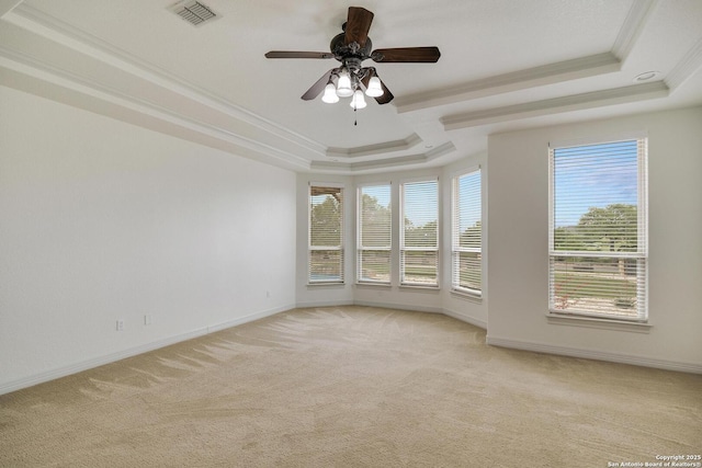 unfurnished room with crown molding, a tray ceiling, visible vents, and light carpet