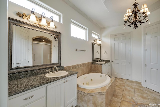 bathroom featuring a sink, an inviting chandelier, a jetted tub, and two vanities