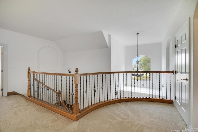 corridor with carpet flooring and an upstairs landing