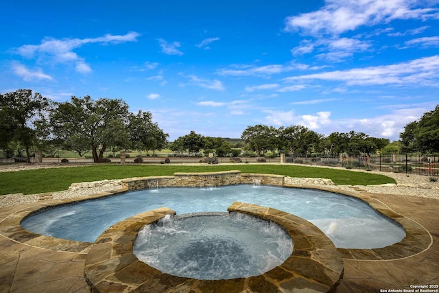 view of pool featuring a yard, a pool with connected hot tub, and fence