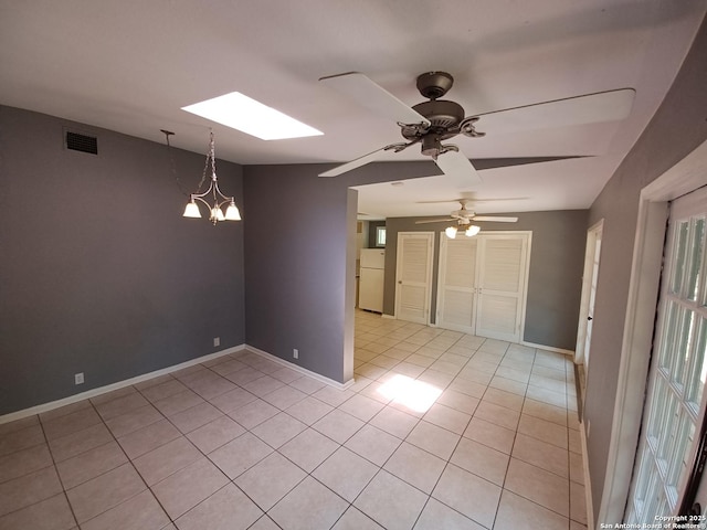 111 Blue Bonnet Blvd, Alamo Heights, TX 78209 - spare room with light tile patterned flooring, ceiling fan with notable chandelier, baseboards, a skylight, and visible vents