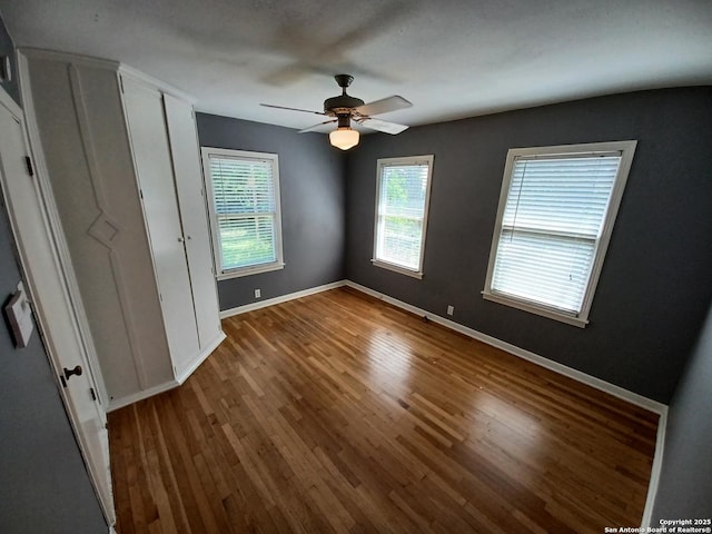 111 Blue Bonnet Blvd, Alamo Heights, TX 78209 - unfurnished bedroom featuring baseboards, a ceiling fan, wood finished floors, and multiple windows