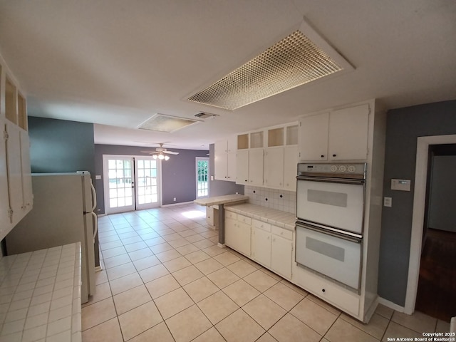 111 Blue Bonnet Blvd, Alamo Heights, TX 78209 - kitchen featuring white cabinets, tile countertops, white appliances, and light tile patterned flooring