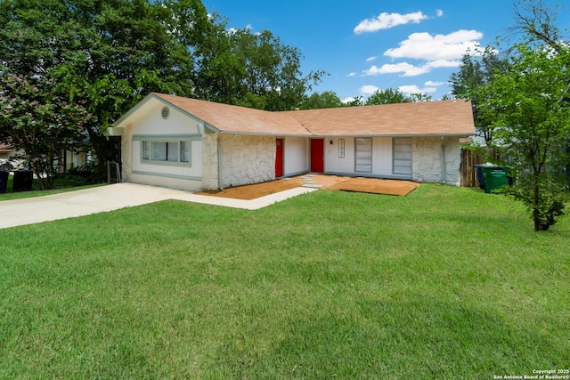 ranch-style home featuring concrete driveway, stone siding, and a front yard
