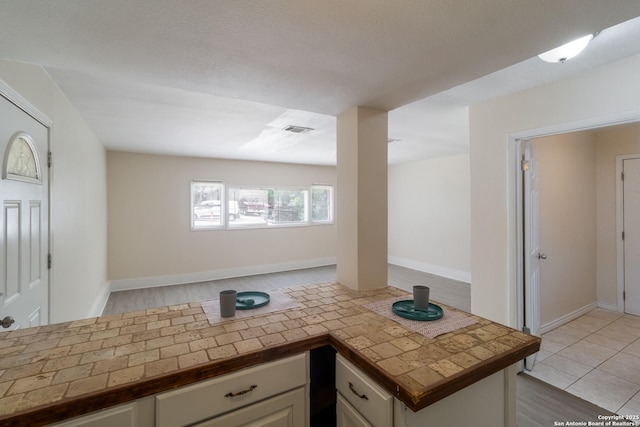 interior space featuring visible vents, open floor plan, and light wood finished floors