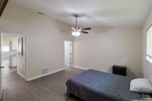 bedroom featuring baseboards, visible vents, wood finished floors, and lofted ceiling