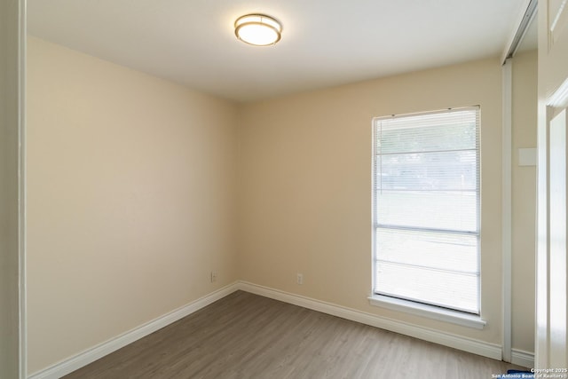 empty room with baseboards and wood finished floors