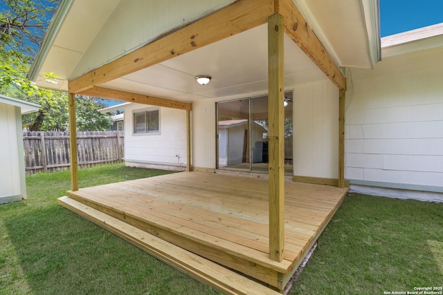 wooden deck with a lawn and fence