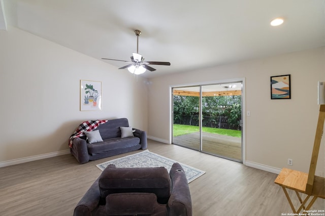 living room with baseboards, light wood finished floors, and ceiling fan