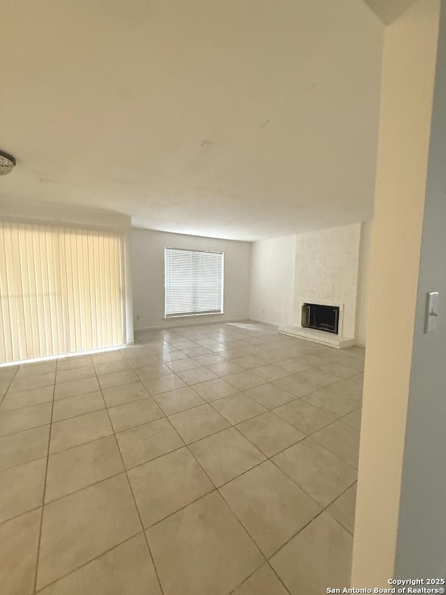 unfurnished living room with tile patterned flooring and a fireplace