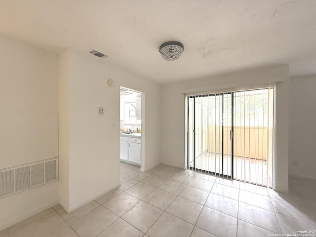 unfurnished room with light tile patterned floors, baseboards, and visible vents