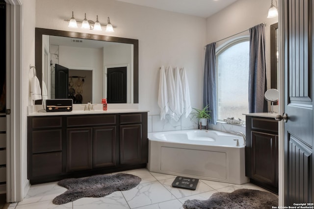 full bath with vanity, a garden tub, marble finish floor, and visible vents