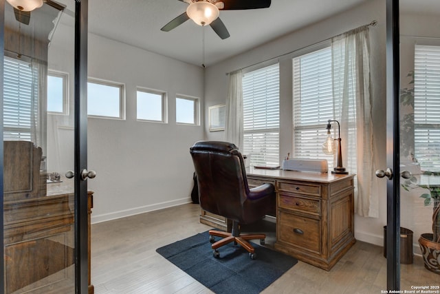 office area with a ceiling fan, french doors, and light wood-style flooring