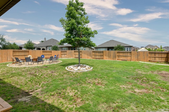 view of yard with a fenced backyard, a patio, and a residential view