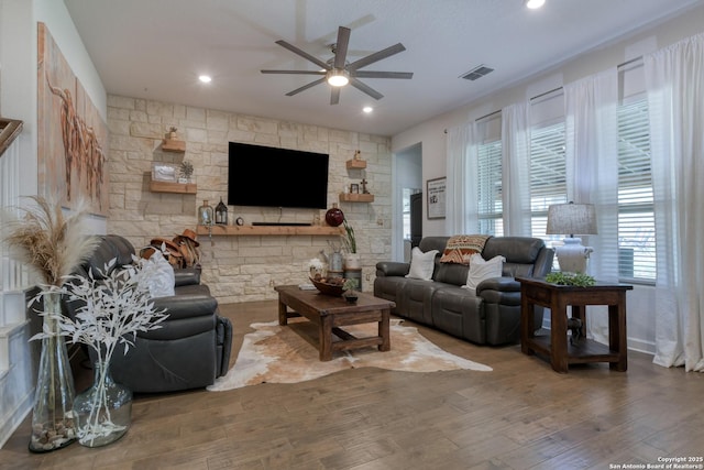 living area with plenty of natural light, ceiling fan, wood finished floors, and visible vents
