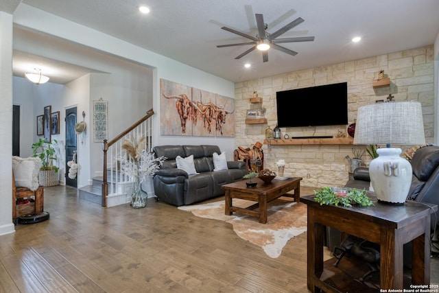 living area with recessed lighting, a ceiling fan, stairs, and wood finished floors