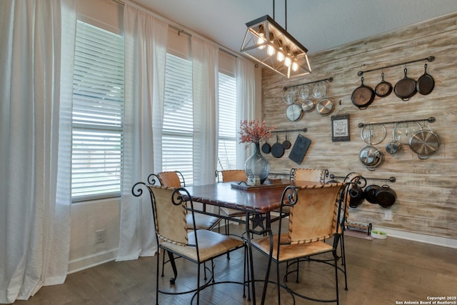 dining room featuring baseboards, a healthy amount of sunlight, and wood finished floors
