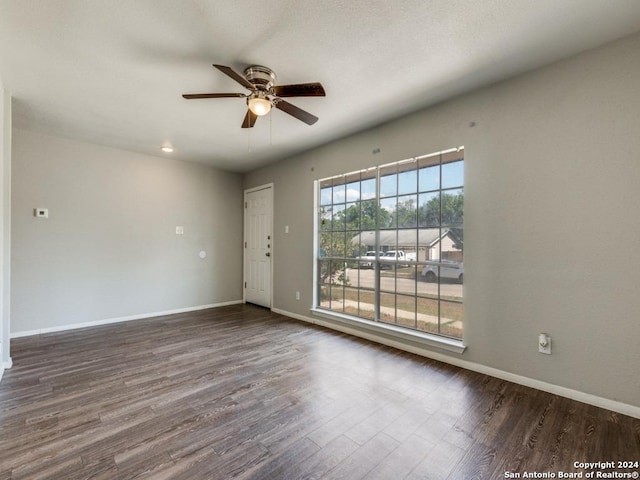 empty room with a ceiling fan, baseboards, and wood finished floors