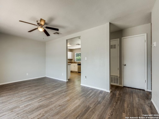 empty room featuring baseboards, a ceiling fan, wood finished floors, and visible vents