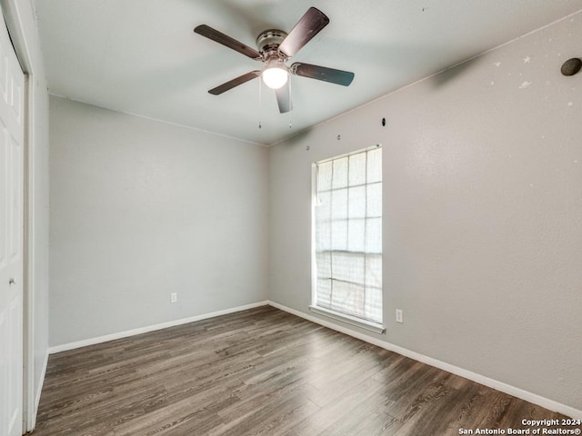unfurnished room with baseboards, ceiling fan, and wood finished floors