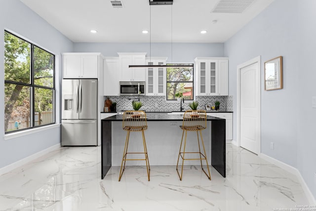 kitchen featuring a center island, baseboards, backsplash, and stainless steel appliances