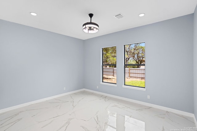 spare room featuring baseboards, recessed lighting, and marble finish floor