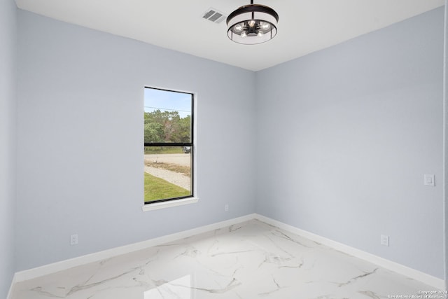 unfurnished room with baseboards and marble finish floor