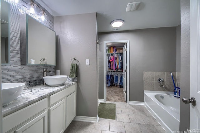 13408 Drop Seed, San Antonio, TX 78254 - full bath featuring decorative backsplash, baseboards, double vanity, a garden tub, and a walk in closet