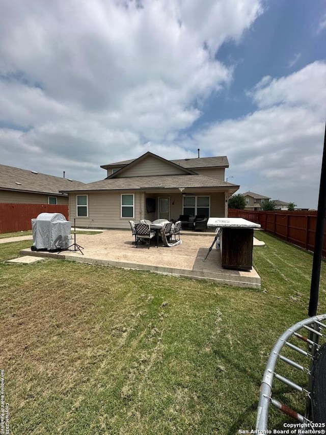 rear view of house with a lawn, a patio, a fire pit, and a fenced backyard