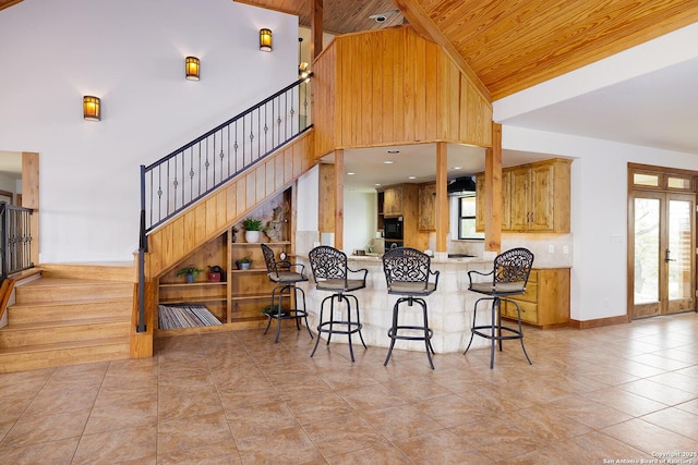 137A Spanish Pass, Boerne, TX 78006 - kitchen featuring wood ceiling, healthy amount of natural light, light tile patterned floors, a kitchen breakfast bar, and black microwave
