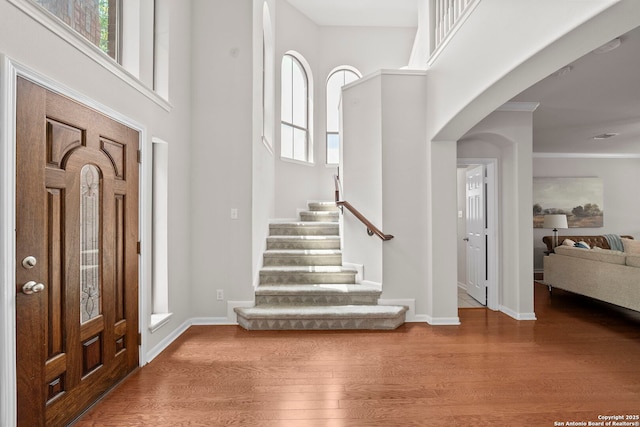 8715 Anton Chico, Helotes, TX 78023 - entrance foyer with arched walkways, baseboards, stairs, and wood finished floors