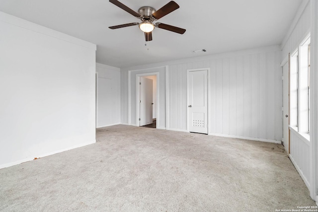 unfurnished room with baseboards, carpet, a ceiling fan, and visible vents