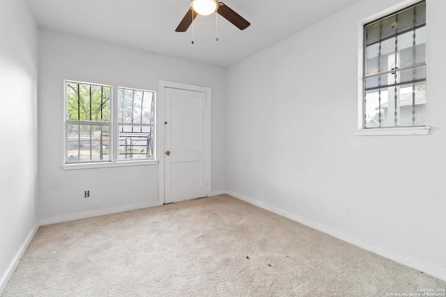 spare room with carpet floors, a ceiling fan, and baseboards