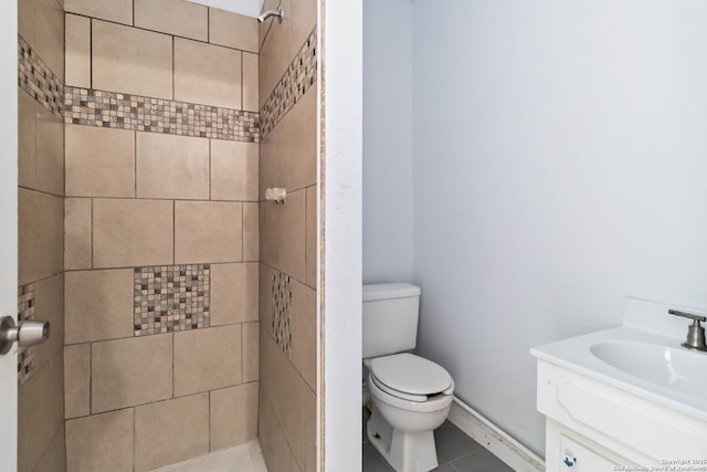 full bath featuring toilet, tile patterned floors, a tile shower, and vanity