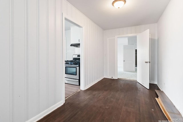 hallway featuring baseboards and dark wood finished floors