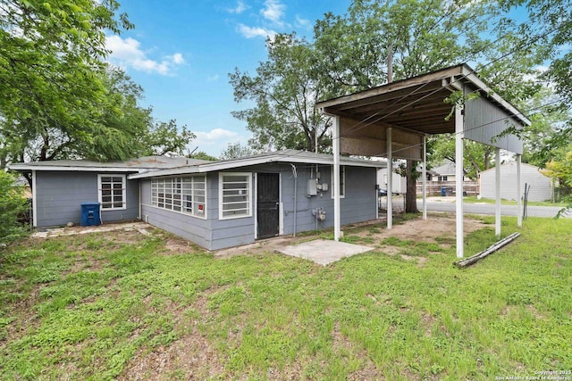 back of house featuring a yard and a carport