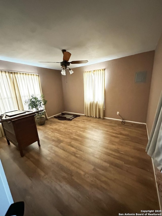 interior space featuring baseboards, ceiling fan, and wood finished floors