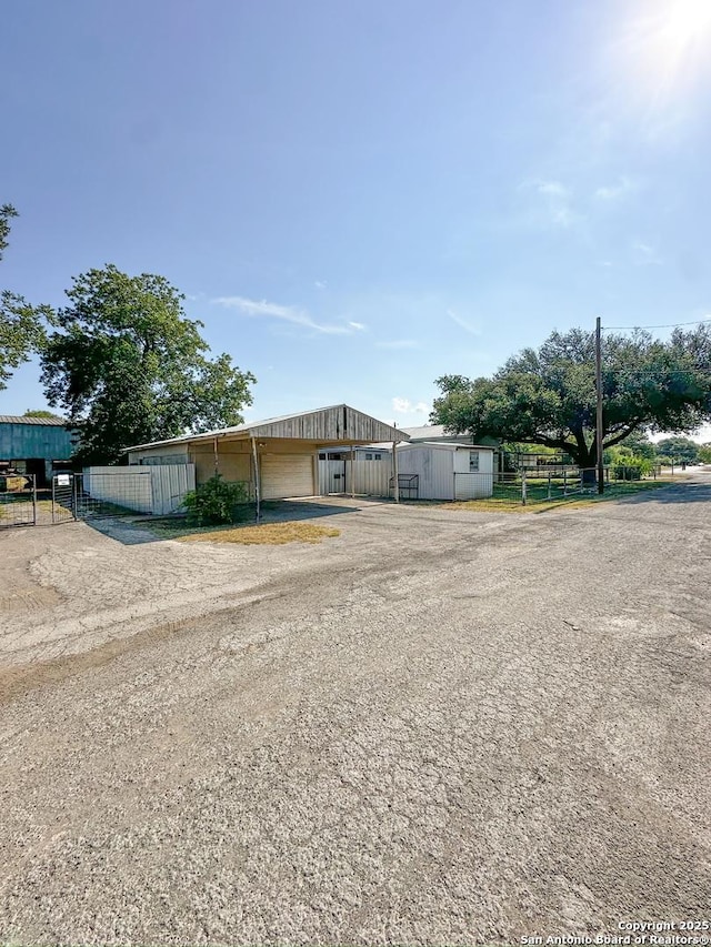 manufactured / mobile home with an outdoor structure, fence, and driveway