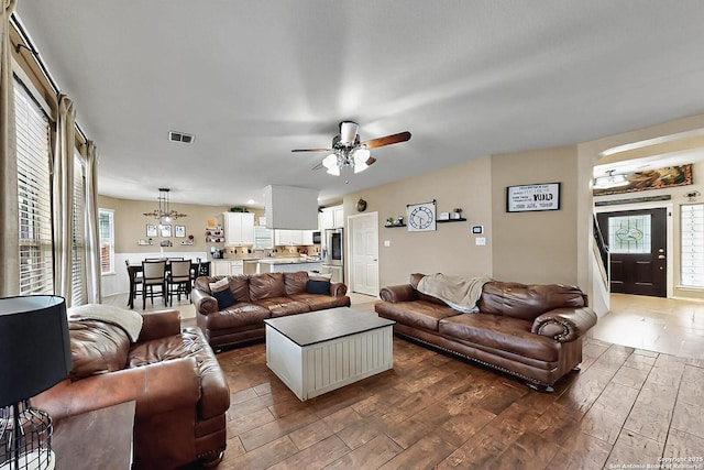 living room with visible vents, ceiling fan, and wood finished floors