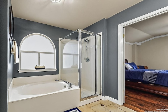 bathroom with baseboards, a shower stall, a bath, and connected bathroom