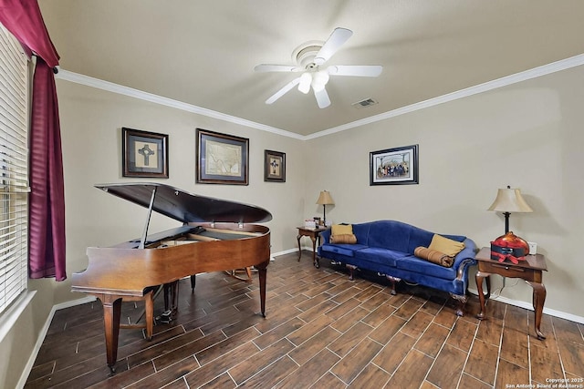 living area with baseboards, ornamental molding, a ceiling fan, and wood finish floors