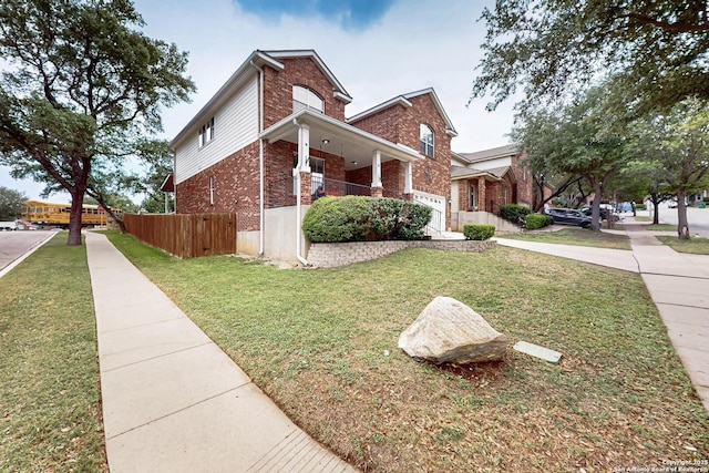 view of home's exterior featuring a lawn, fence, covered porch, and brick siding
