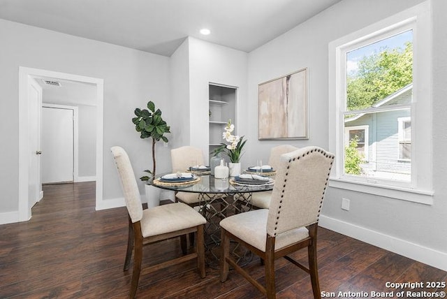 dining room with baseboards, visible vents, plenty of natural light, and wood finished floors
