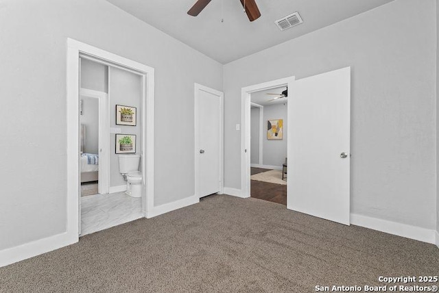 unfurnished bedroom with visible vents, baseboards, ensuite bath, and dark colored carpet